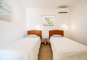 deux lits dans une petite pièce avec une fenêtre dans l'établissement Casa Cubo - Amazing Central 6 bedroom Villa, à Carvoeiro 52 autres photos