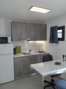a kitchen with a sink and a white refrigerator at Yumbo Rainbow Homes D in Maspalomas