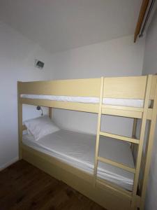 a bunk bed in a room with white walls at Studio centre station avec balcon in LʼHuez +1 photo