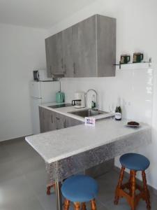 een keuken met een aanrecht en twee blauwe krukken bij Yumbo Rainbow Homes C in Maspalomas