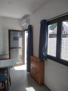 een kamer met 2 ramen en een houten dressoir bij Yumbo Rainbow Homes C in Maspalomas +23 foto's