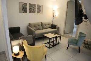 ein Wohnzimmer mit einer Couch und einem Tisch und Stühlen in der Unterkunft Maison La Belfort You proche TechnHom in Belfort