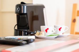 two coffee cups on a counter next to a microwave at Hotel Schönbrunn by Vienna Living Apartments in Vienna