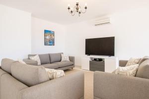 a living room with two couches and a flat screen tv at Casa Filipa Lower Floor - Charming 3-Bedroom Villa with Heated Pool in Praia do Carvoeiro