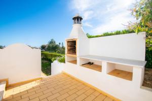 a lighthouse on the side of a white building at Casa Filipa Lower Floor - Charming 3-Bedroom Villa with Heated Pool in Praia do Carvoeiro