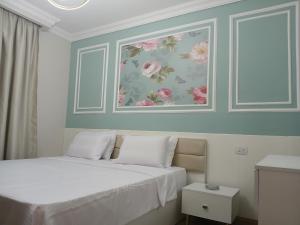 a bedroom with a bed with a painting on the wall at Dar Residence - Madinaty B12 - U2 - 2 BR - New Cairo in Madinaty