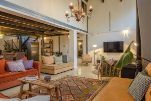 ミツペ・ラモンにあるIBEX unique Desert Innのリビングルーム(オレンジ色のソファ、テレビ付)