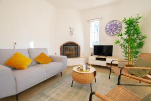 ein Wohnzimmer mit Sofa und Fernseher in der Unterkunft C65 Quinta do Paraiso - Charming 2-Bedroom Bungalow in Carvoeiro