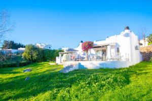 Ein weißes Haus auf einem Hügel mit einem grünen Feld in der Unterkunft C65 Quinta do Paraiso - Charming 2-Bedroom Bungalow in Carvoeiro