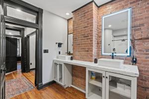 a bathroom with two sinks and a brick wall at Spacious, Historic Logan Circle Rowhouse in Washington +89 photos
