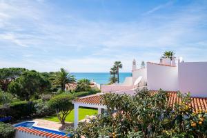 Außenansicht eines Hauses mit dem Meer im Hintergrund in der Unterkunft Casa Miguel - Family-Friendly 3-Bedroom Villa with Private Pool in Benagil