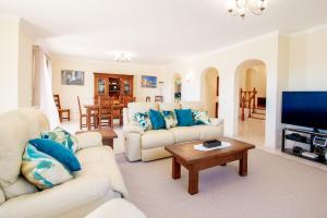 a living room with white furniture and a flat screen tv at Casa Filipa Full house - Spacious Villa with Private Pool & Jacuzzi in Praia do Carvoeiro