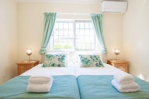 a bedroom with a large bed with blue curtains at Casa Filipa Full house - Spacious Villa with Private Pool & Jacuzzi in Praia do Carvoeiro +66 photos