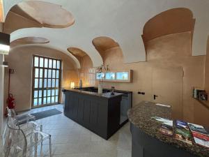 a kitchen with an island in a room with arched ceilings at DOMUS Hotel in Caselle Torinese