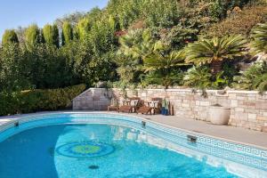 a swimming pool with two chairs next to a wall at Villa Rosa del Garda Golf and Bike in Garda