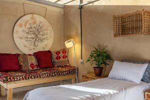 ミツペ・ラモンにあるIBEX unique Desert Innのベッド1台、ソファ(枕付)が備わる客室です。