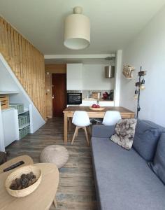 a living room with a blue couch and a kitchen at Duplex de montagne 4 personnes in Uvernet
