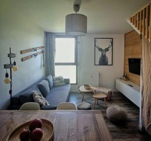 a living room with a blue couch and a table at Duplex de montagne 4 personnes in Uvernet
