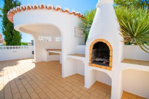 eine Terrasse mit einem Pizzaofen in einem Haus in der Unterkunft The Gaff - Great 5-Bedroom Villa in Poço Partido