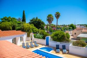 ein Resort mit Swimmingpool, Stühlen und Palmen in der Unterkunft The Gaff - Great 5-Bedroom Villa in Poço Partido