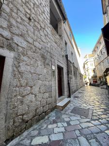 a stone building with a door on a street at Vita Mundo in Kotor