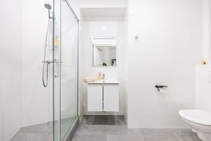 een witte badkamer met douche en toilet bij Nation Confort & Espace in Parijs +13 foto's