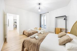 twee bedden in een kamer met witte muren bij Nation Confort & Espace in Parijs