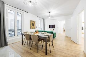 een eetkamer met een tafel, stoelen en een bank bij Nation Confort & Espace in Parijs