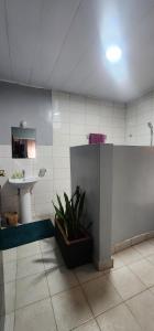 a bathroom with a sink and a mirror and a plant at Private cosy home close to city center with views in Kigali +56 photos