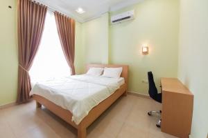 Postel nebo postele na pokoji v ubytování RedDoorz Syariah at UIN Suska GuestHouse