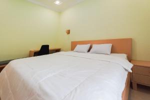Postel nebo postele na pokoji v ubytování RedDoorz Syariah at UIN Suska GuestHouse