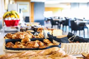 a table topped with baskets of bread and pastries at Le Saint Aubert in Le Mont Saint Michel