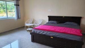 ein Schlafzimmer mit einem großen Bett mit einer rosa Decke in der Unterkunft Roopa Resorts in Araku