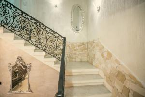 a staircase with a wrought iron railing and a mirror at Sliema Central Iprime Suites in Sliema