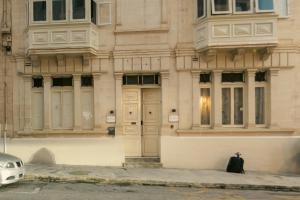 a building with a black bag sitting in front of it at Sliema Central Iprime Suites in Sliema