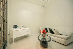 a white living room with a couch and a table at Sliema Central Iprime Suites in Sliema