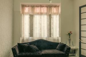 a living room with a couch in front of a window at Sliema Central Iprime Suites in Sliema