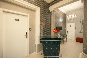 a hallway with a door and a table with flowers on it at Sliema Central Iprime Suites in Sliema