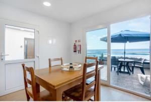 a dining room with a table and a view of the ocean at Casa dos avós in São Vicente