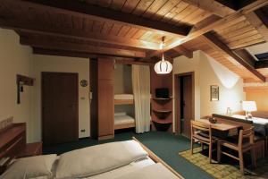 ein Schlafzimmer mit einem Bett und einem Schreibtisch sowie ein Zimmer in der Unterkunft Residence Baumgartner in Völs am Schlern