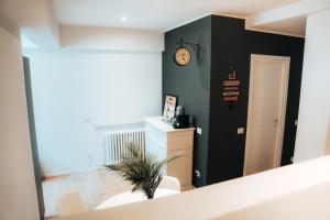 Habitación con espejo y reloj en la pared en Home sweet home san siro, en Milán