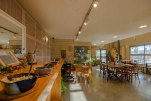 ミツペ・ラモンにあるIBEX unique Desert Innの木製のテーブルと椅子、テーブル、テーブルサーチャー付きのレストラン