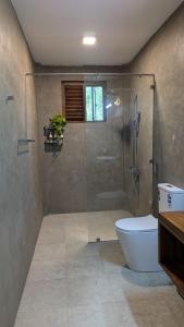 a bathroom with a shower and a toilet at Nuwans Countryside Apartment in Tangalle +20 photos