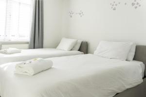 2 bedden in een slaapkamer met witte lakens bij 3 BDR House By Caledonia Luxe Stays Short Lets & Serviced Accommodation Airdrie in Airdrie