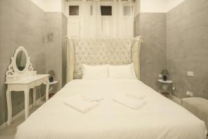 a bedroom with a white bed and a mirror at Sliema Central Iprime Suites in Sliema