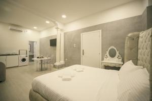 a bedroom with a white bed and a bathroom at Sliema Central Iprime Suites in Sliema