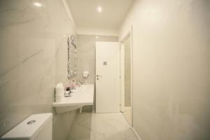 a white bathroom with a sink and a shower at Sliema Central Iprime Suites in Sliema