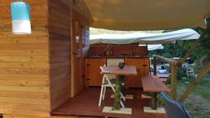 an outdoor kitchen with a table and an umbrella at Camping RioRequesa in Campore