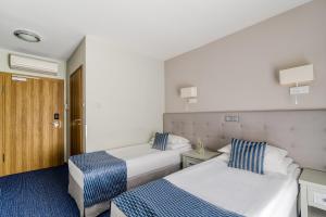 a hotel room with two beds and a door at Hotel Aqua Sopot - Destigo Hotels in Sopot +28 photos