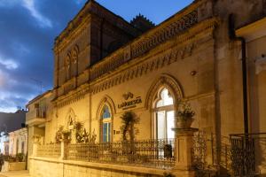 un edificio con un balcone sul lato di La Moresca Hotel a Marina di Ragusa
